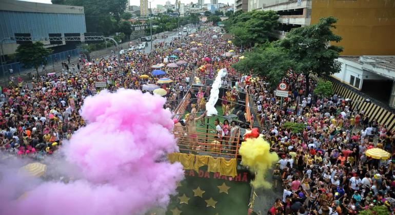 Vista aérea da passagem do Bloco de rua Então Brilha! com mais de quatrocentas pessoas, durante o dia. 