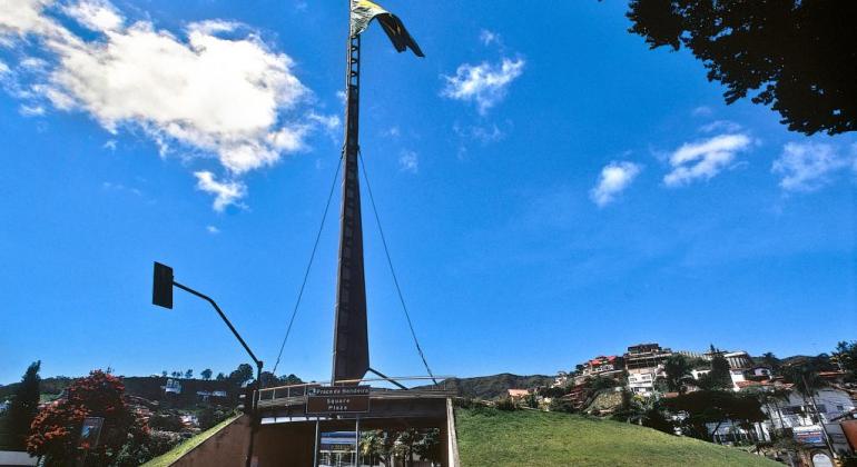 Praça da Bandeira, com mastro e bandeira, durante o dia. 