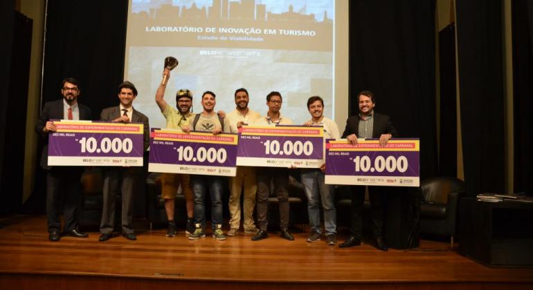  Quatro vencedores do laboratório de experimentação do Carnaval exibem cheques simbólicos de dez mil reais. 