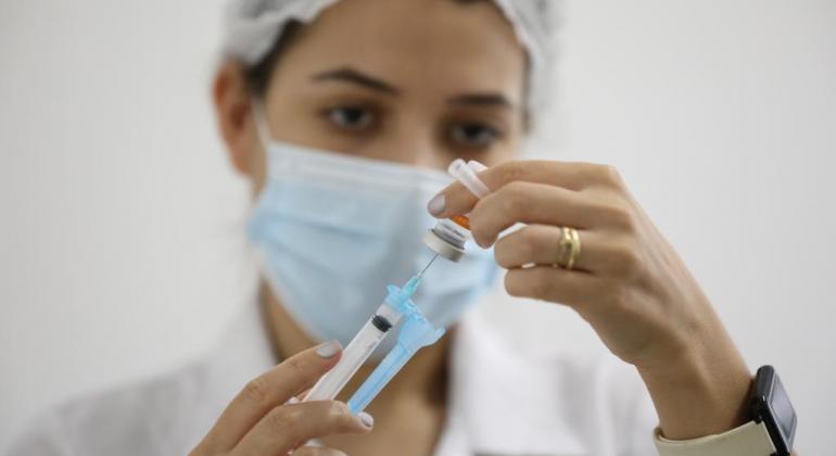 Saiba como será a vacinação contra a Covid-19 no dia 31, véspera de Ano Novo Profissional prepara vacina contra a Covid-19