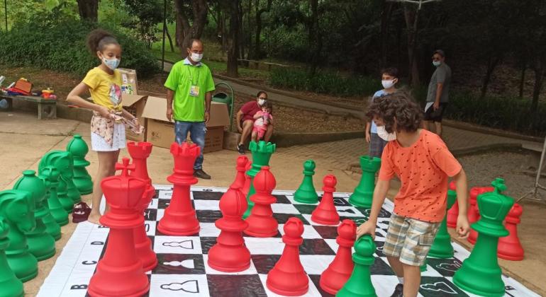 Crianças brincam de xadrez em parque municipal