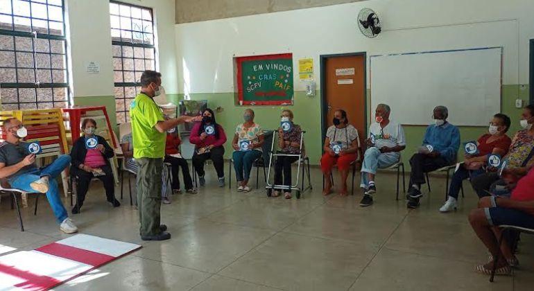 Imagem de profissional da BHTrans durante orientação para idosos, com cuidados sobre o trânsito