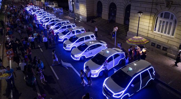 Taxis iluminados com luzes de Natal estacionados na Praça da Liberdade