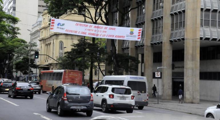 Faixa com os dizeres: "Detector de avanço do sinal a partir de 5/12/2018. Respeitar o sinal vermelho é lei e evita acidentes" na avenida Afonso Pena, no Centro de Belo Horizonte.
