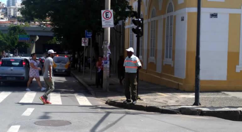 Agente de trânsito observa transeunte na área central de BH. 