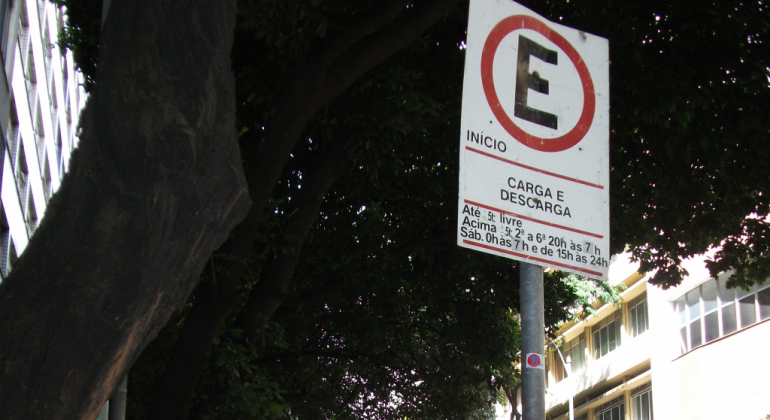 Regras de carga e descarga e restrições a carretas e caminhões otimizam trânsito Placa de estacionamento com orientações sobre carga e descarga