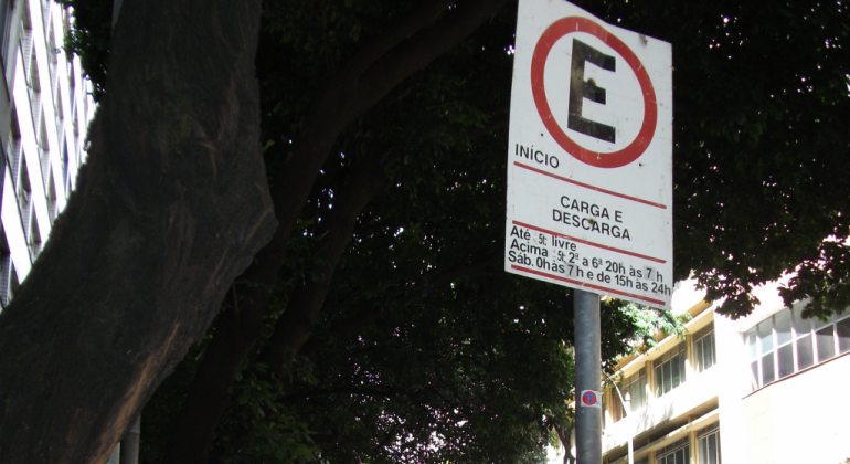 Placa de estacionamento com orientações sobre carga e descarga