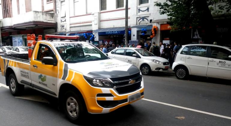 Picape da BHTrans com sinalizadores de trânsito na traseira, nas ruas, durante o dia. 