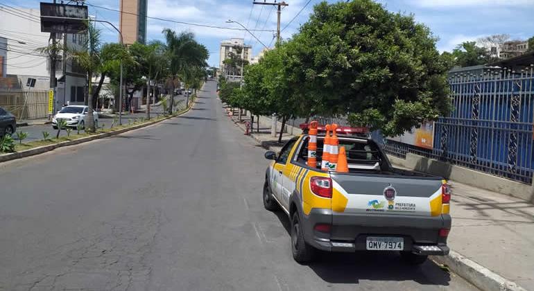 Caminhonete da NHTrans, com quatro cones de sinalização, em avenida, durante o dia. 