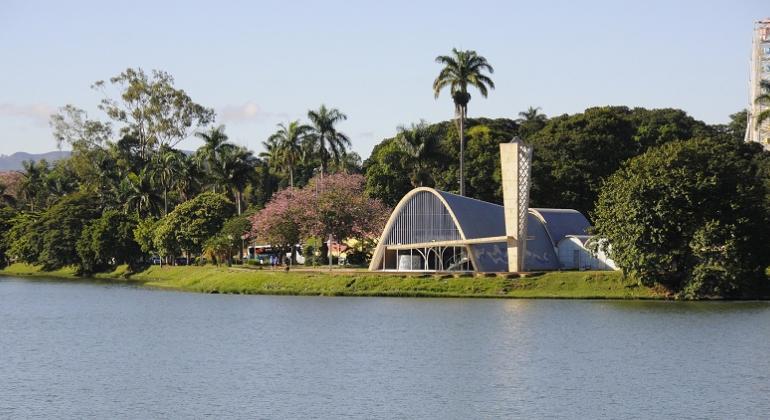 Vista da Igrejinha da Pampulha com Lagoa da Pampulha à frente, durante o dia. 