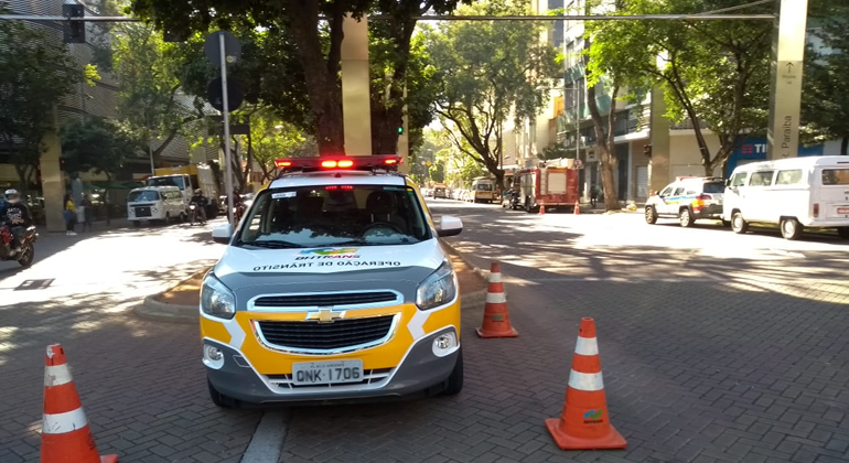 Carro da BHTrans ao lado de cones de trânsito em avenida, durante o dia. 