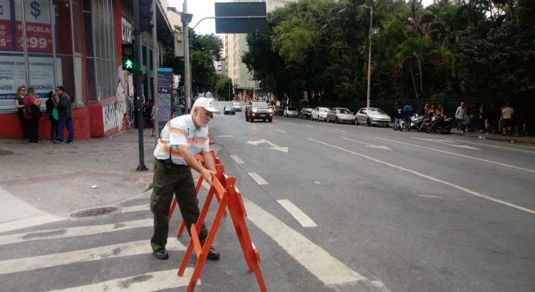 Imagem de agente da BHTrans sinalizando ruas do centro da capital