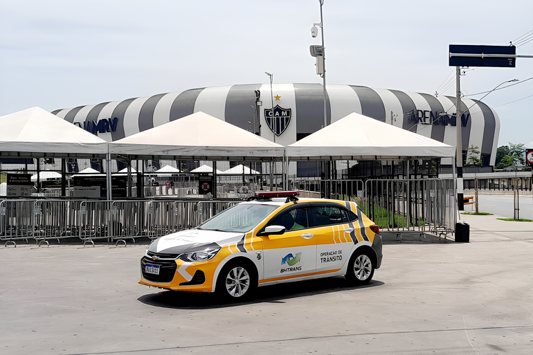 Carro da BHTrans na esplanada da Arena MRV com o estádio ao fundo. 