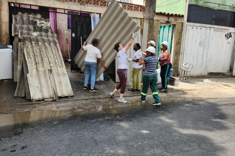 Assistência técnica da PBH capacita mulheres chefes de família para reforma em moradias no Vale do Jatobá e Ocupação Vitória Imagem de seis mulheres trabalhando em reforma de moradia, algumas delas carregando telhas.
