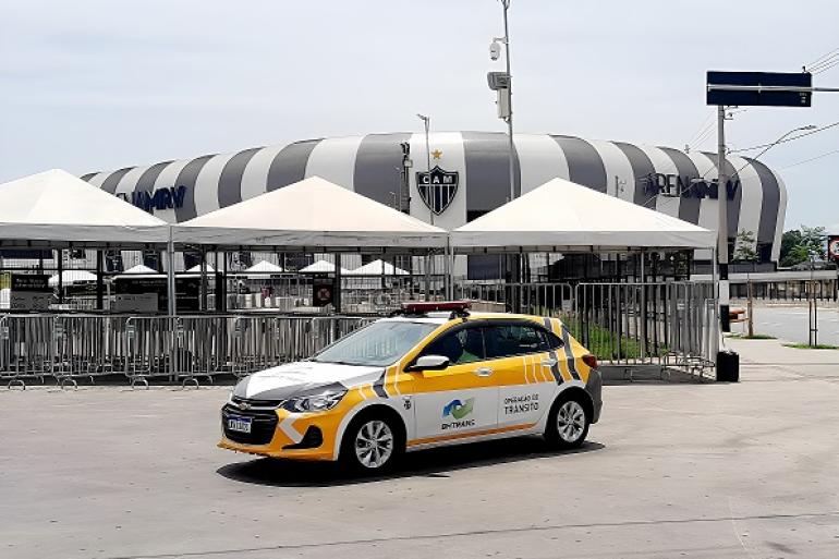 Imagem mostra um carro da BHTrans em primeiro plano com a Artena MRV ao fundo.