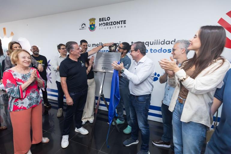 Prefeitura de BH investe em modernização e ampliação de estrutura da rede municipal de saúde animal Foto do prefeito Álvaro Damião descerrando a placa de inauguração do Casa, com um cachorro ao fundo.