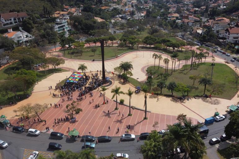 Imagem aérea mostra a Praça durante a inauguração com concentração de pessoas em torno do marco princiál.