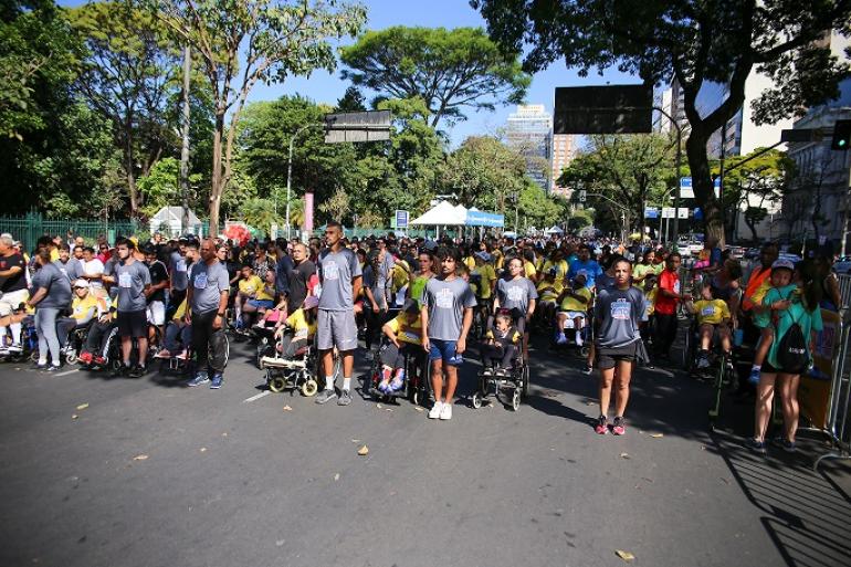 Inscrições para a tradicional Corrida Rústica PCD na Afonso Pena vão até 21 de agosto Atletas vestidos com roupas esportivas reunidos antes do início de uma corrida. Na imagem é possóvel ver parte da rua margeada por várias árvores.