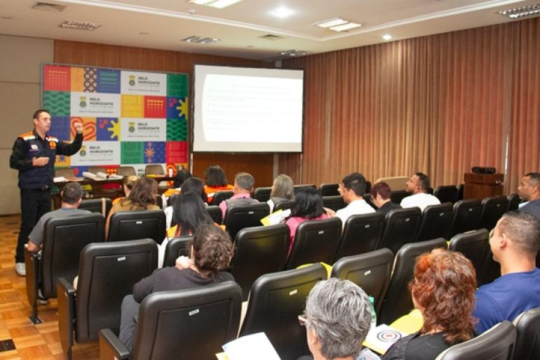 Capacitação aprimora resposta da Defesa Civil a emergências em BH Participantes do treinamento da Defesa Civil assistem sentados à explicação de especialista