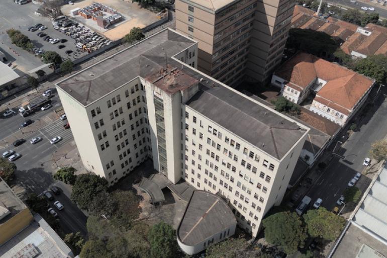 Vista aérea do complexo de prédios que integram a Faculdade de Engenharia da UFMG, na região central de Belo Horizonte, que está sem uso há 17 anos. Edifícios em cor cinza claro, ladeados pela Avenida do Contorno e rua Espírito Santo.