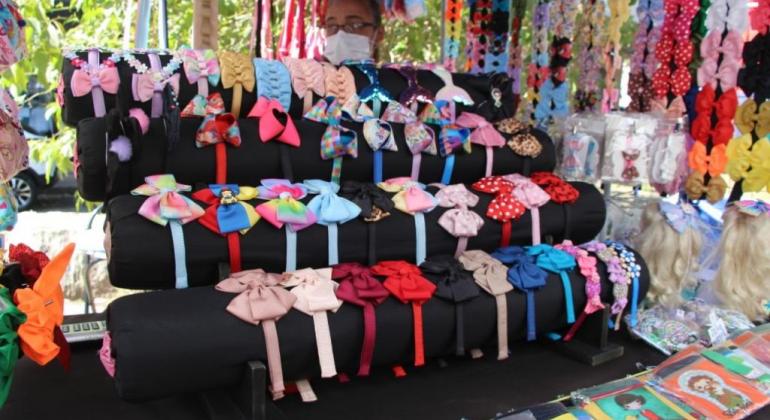 Programa Espaço da Cidadania gera renda e dignidade para artesãs do município Barra em feira com a exposição de laços de fita coloridos