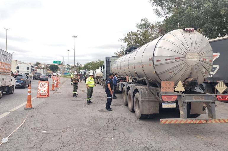 PBH faz nova operação conjunta com a ANTT no Novo Anel para fiscalizar veículos que transportam cargas perigosas Imagem mostra um caminhão tanque na lateral do Novo Anel sendo ficalizado por fiscais. Na foto há também um homem de jaqueta azul próximo ao caminhão.