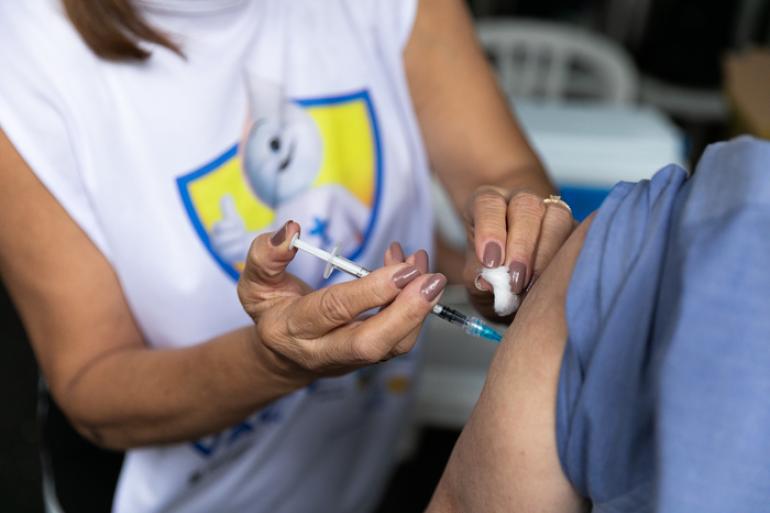 PBH reforça chamado para vacinação contra a gripe em idosos, gestantes e crianças de 6 meses a menos de 6 anos Imagem de uma enfermeira aplicando uma injeção no braço de uma pessoa, sem identificação dos personagens