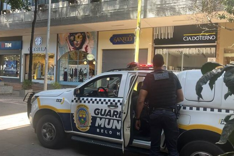 Guarda Municipal reforça segurança nas áreas comerciais para as compras do Dia dos Pais Viatura da Guarda Municipal de frente para três lojas, na rua. Agende da Guarda, uniformizado, parado ao lado da viatura, que está com a porta traseira aberta.
