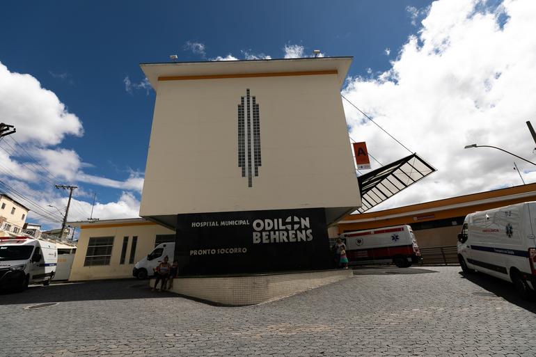Prédio do Complexo Hospitalar Odilon Behrens, rodeado por quatro ambulâncias em uma rampa
