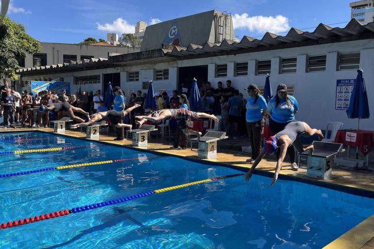 Alunos que participam dos Jogos Escolares de Belo Horizonte pulam na piscina em competição de natação