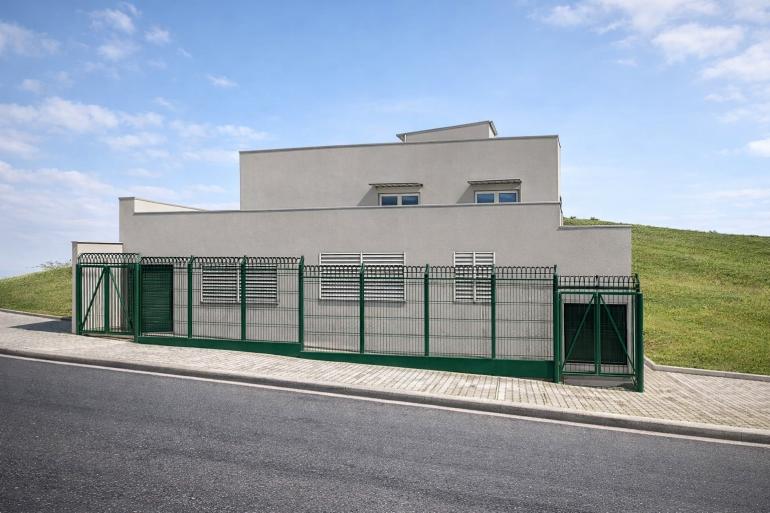 PBH vistoria imóveis do entorno antes de iniciar as obras do novo Centro de Saúde Nossa Senhora de Fátima Fachada de edificação com estrutura moderna, cercada por gradil e área verde no entorno.