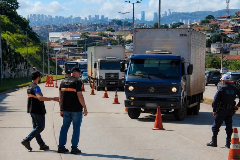 Blitz da Operação Oxigênio combate emissão irregular de poluentes nesta sexta-feira (17) Fiscais da PBH com coletes pretos fiscalizam caminhões em via de Belo Horizonte