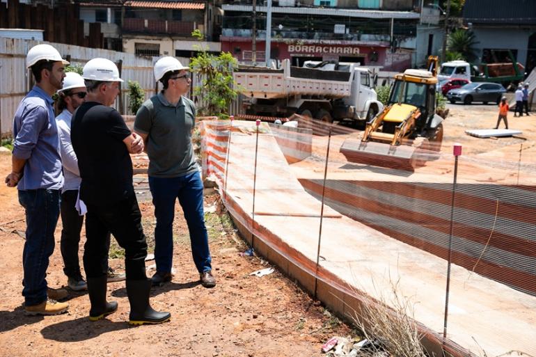 https://prefeitura.pbh.gov.br/noticias/prefeitura-de-bh-retoma-obras-de-macrodrenagem-da-praca-das-aguas-para-ampliar-protecao Foto do prefeito Álvaro Damião e outros servidores municipais usando capacete de proteção, em visita ao canteiro de obras da Praça das Águas