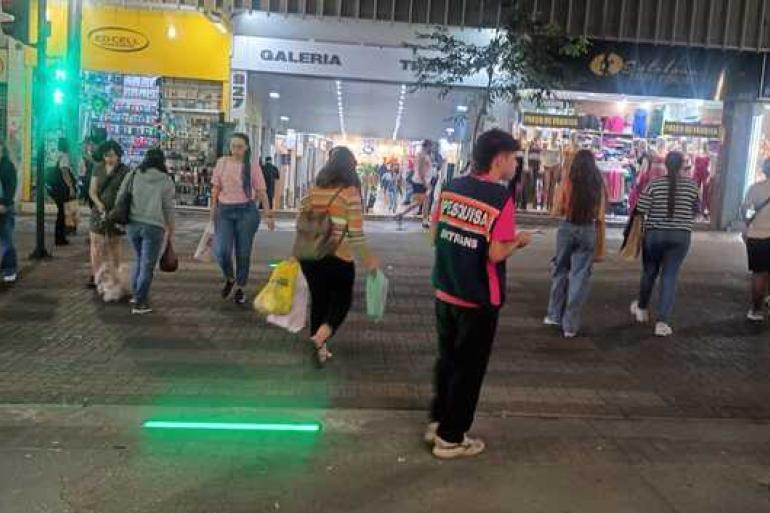 PBH amplia teste para segurança nas travessias de pedestres Semáforo de LED no chão à noite e pedestres atravessando a rua