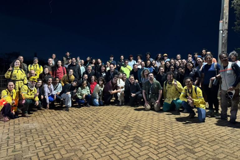 PBH abre nova edição de passeio noturno no Parque da Serra do Curral Grupo com umas 30 pessoas, em semi-círculo, posa para foto, em uma praça de concreto, antes de iniciar uma caminhada noturna por trilha urbana em Belo Horizonte.