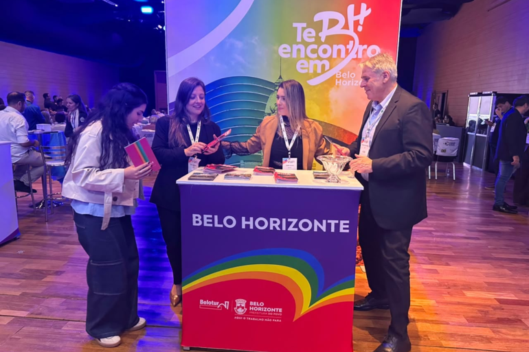 Belotur apresenta Guia LGBT+ em evento de turismo em São Paulo Representantes da Belotur no evento com cartazes nas cores LGBT+ ao fundo