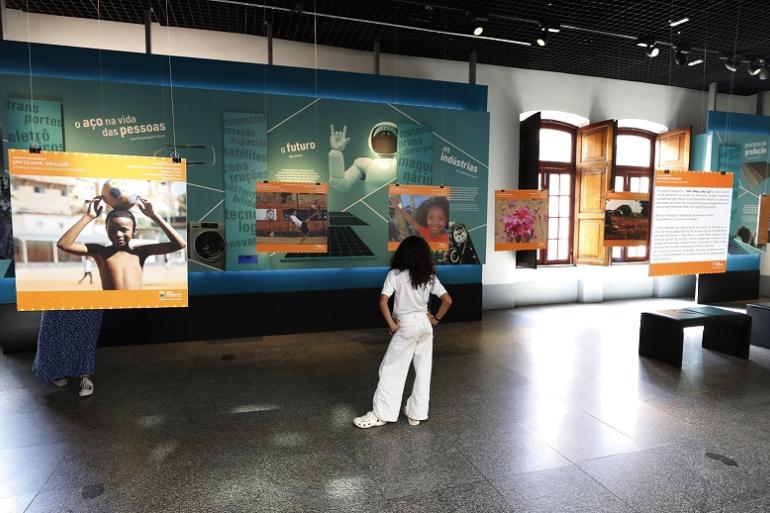 Projeto “Um Olhar, Uma Luz” convida estudantes a refletirem sobre a interferência da inteligência artificial nas fotos Imagem mostra uma menina de costas observando uma exposição de fotos
