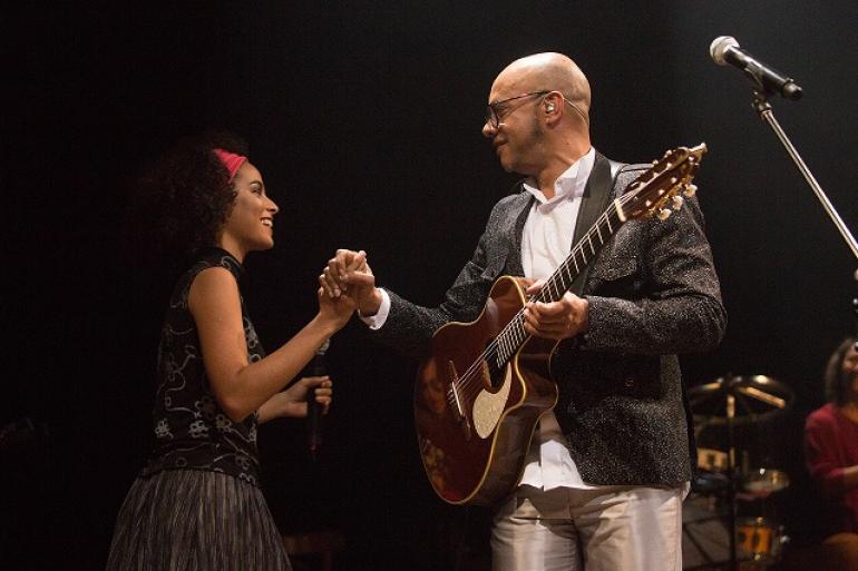 Circuito Municipal de Cultura presta homenagem pelos dez anos sem Vander Lee com show de Laura Catarina Imagem mostra em um cenário com pouca luz o cantor vander Lee de mãos dadas com a filha Catarina. O cantor está com um violão.