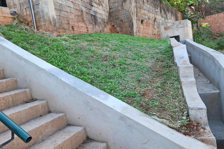 Imagem de estrutura de concreto construída para escoamento de água de chuva e parte gramada pra conter erosão
