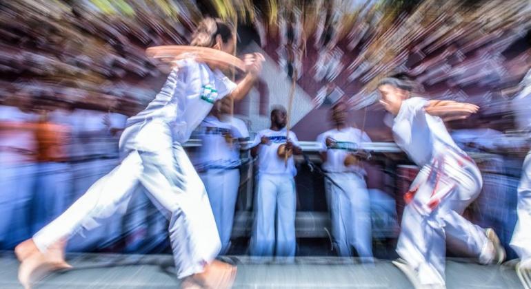 Duas pessoas lutando capoeira