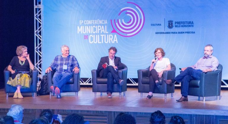 Abertura da 5ª Conferência Municipal de Cultura incluiu a discussão de temas como cultura, território e democracia. Foto: Ana Beatriz Baêta Mesa de abertura da 5ª Conferência Municipal de Cultura, com cinco integrantes sentados.