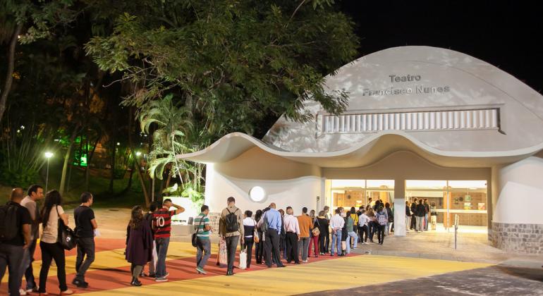 Teatro Francisco Nunes com fila de espectadores à noite.