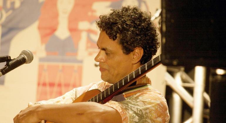 Show “Viola Brasileira” tem composições autorais e do cancioneiro popular, permeadas por algumas prosas sobre o universo da viola brasileira. Foto: Raíra Morais Músico, sentado, de lado, abraçando sua viola.