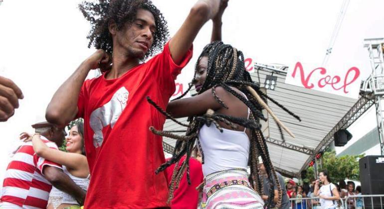 O evento visa contribuir para a formação de público e artistas, além de fomentar a dança, principalmente nas periferias. Foto: Marcio José Homem e mulher dançam ao ar livre.