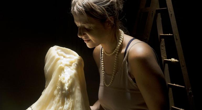 Exposição cria relações entre o mito de Penélope e a história do Museu Mulher sentada, de olhos fechados, em frente a uma estátua