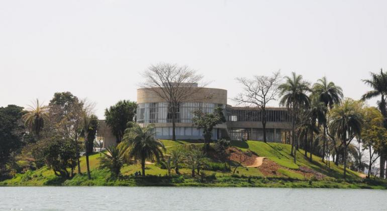 Parte de trás do Museu da Arte da Pampulha, com lagoa da Pampulha à frente, durante o dia. 
