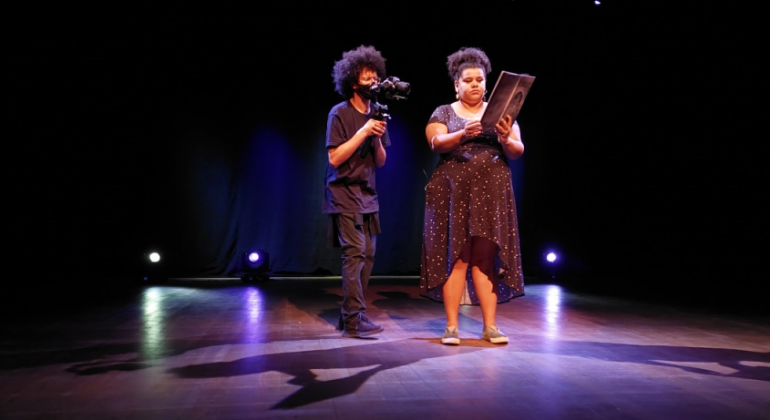 Cinegrafista filmando uma mulher lendo história 