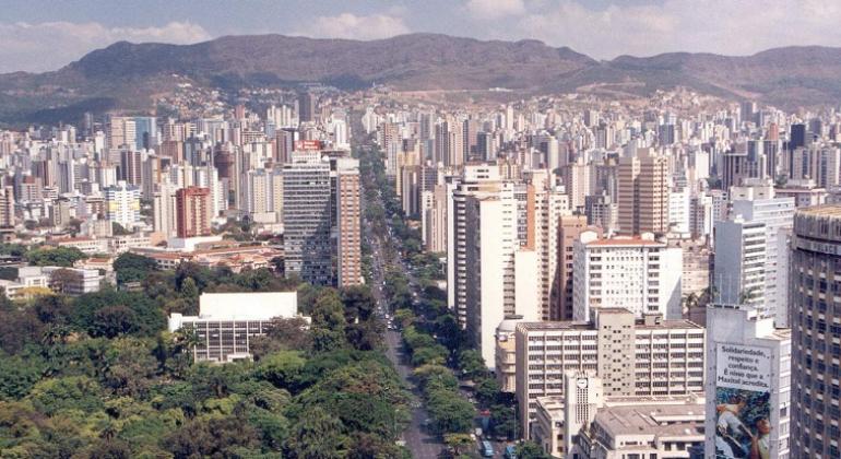 Vista aére da avenida Afonso Pena, com a cidade de Belo Horizonte e a Serra do Curral ao fundo, durante o dia.
