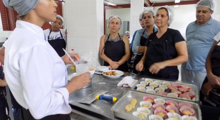 Oficinas de gastronomia gratuitas são oferecidas para a população Pessoas recebem informações em aula de gastronomia