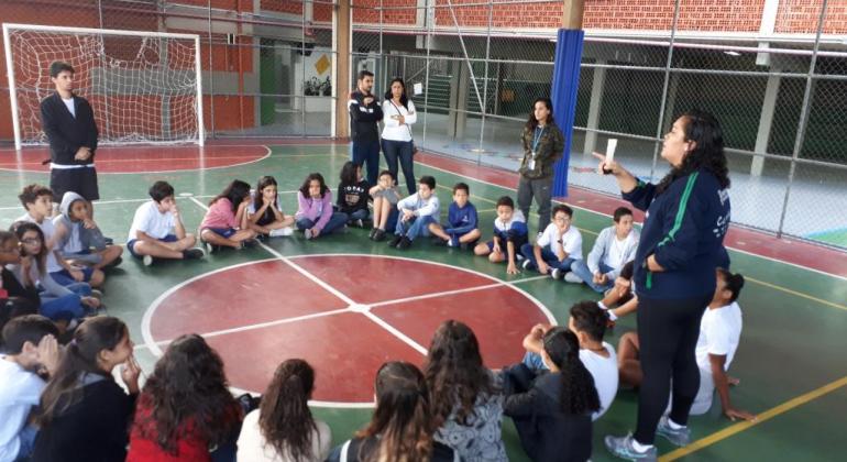 Crianças em aula na quadra de escola